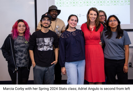 Math professor Marcia Corby, in red dress, stands with students in her Statistics class after receiving Phoenix College's 2024 Distinguished Teaching Award 