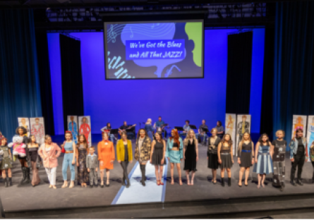 Phoenix College Fashion Club members produced the 2024 Fashion show centered on fashion illustrations and denim; the designers and models pose on stage after the show