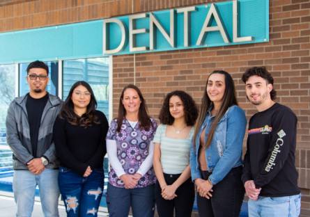 PC Dental Hygiene scholarship recipients with their faculty member standing outside dental building
