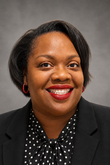 Almetra Walker headshot against grey wall