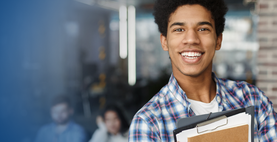 Student in front of building holding books