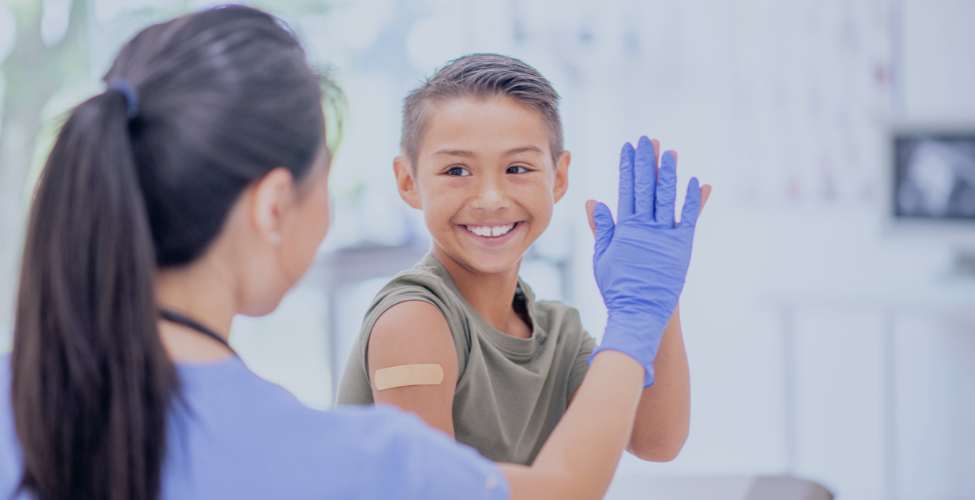 Nurse giving a high-five to a boy who received an immunization