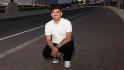 Phoenix College Nursing student Victor Salinas on a bridge smiling; he is recipient of the Equality Maricopa PRISM Scholarship