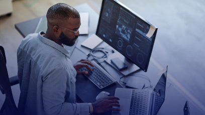 African American business man working at a laptop with multiple screens