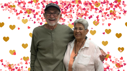 Former Phoenix College students Pat Murphy and Angela Perea-Murphy stand side by side, Pat's arm around Angela with a digital backdrop of hearts