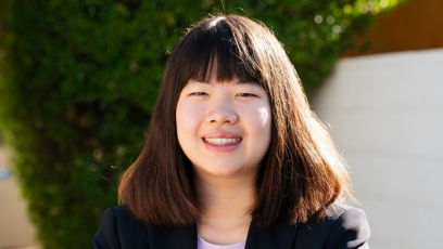 Headshot of Olina Fong on campus with a white background and triangle of green foliage behind her