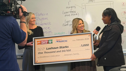 LaShaun Starks accepting $1,000 big check and silver apple award in her classroom