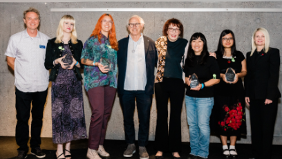 On a stage at the Phoenix Art Museum, Vanguard Award winners stand holding their awards with Phoenix College Art Program Director Jay Hardin, artist Eric Fischl, artist Marilyn Minter, and Phoenix College President Kimberly Britt