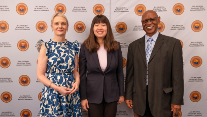 Olina Fong, dressed in a dark blue pant suit with pink top, stand between Dr. Kimberly Britt in a blue and white floral dress, and Wilbert Nelson, dressed in a dark gray suit at the All-AZ Academic Team ceremony