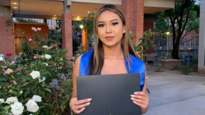 Alyssa posing with her diploma in Pastor Plaza on Phoenix College campus