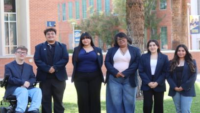 A group of Phoenix college students stand in front of a tree