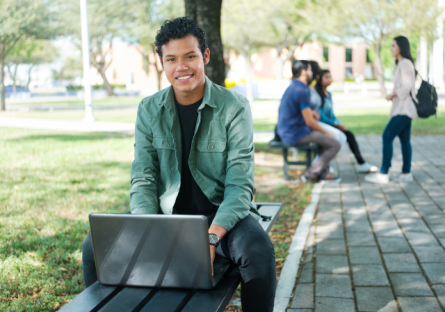 Student on laptop studying outside