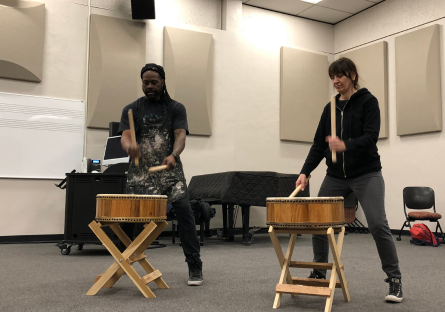 Phoenix College painting students playing Taiko drums during an interdisciplinary workshop exploring mindfulness in drumming and painting