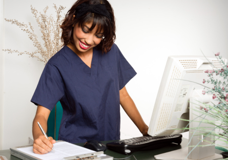 Woman in scrubs at a desk