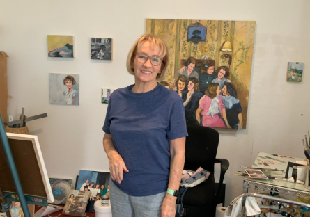 Patrice Sullivan stands in her home studio with her painting works in progress behind her. After attending an artist residency in Mexico, she is taking Spanish at Phoenix College. 