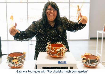Phoenix College student Gabriela Rodriguez points to her three ceramic vessels titled "Psychedelic mushroom garden" during an exhibition at the Phoenix Art Museum