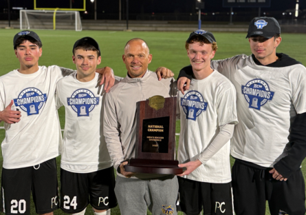 Phoenix College Men's Soccer Head Coach David Cameron stands with four of his players holding the championship plaque