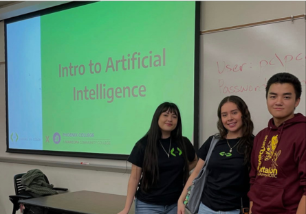 Kenneth Ho, right, Shelby Alonso, center, and another Coding in Color staff person stand in front of their presentation, Introduction to AI, projected on a screen in a Phoenix College classroom