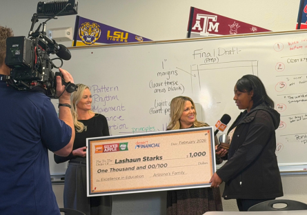 LaShaun Starks accepting $1,000 big check and silver apple award in her classroom