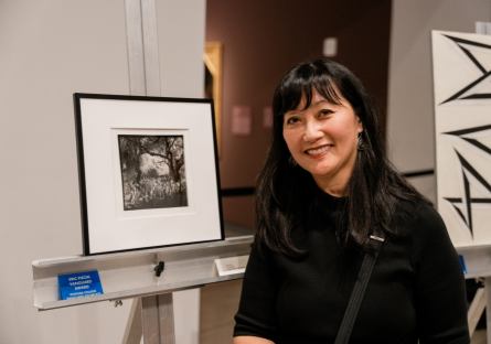 Phoenix College photo student Akie Clark stand next to her photograph, "Community," which won her a Vanguard Award in Photography
