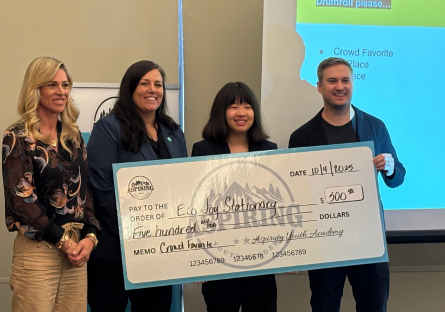 Olina Fong stands with the judges of the Aspiring Youth Academy's pitch competition holding a check for $500 for being awarded crowd favorite 