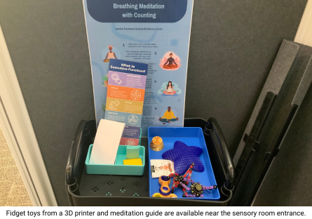 Fidget toys in a cart by the sensory room entrance are made on a nearby 3D printer and a printed cards offers instructions on Breathing Meditation with Counting and What is Executive Function?
