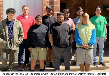 Transitioning Learners to College 2022 - 23 participants stand on the steps in front of Bulpitt Auditorium with program facilitator and instructor Bryan Heckler, back left in coral shirt. 