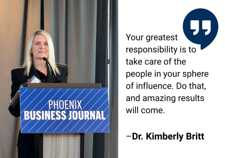 Dr. Kimberly Britt stands at a Phoenix Business Journal podium next to a quote of hers that reads, "Your greatest responsibility is to take care of the people in your sphere or influence.  Do that, and amazing results will come." 