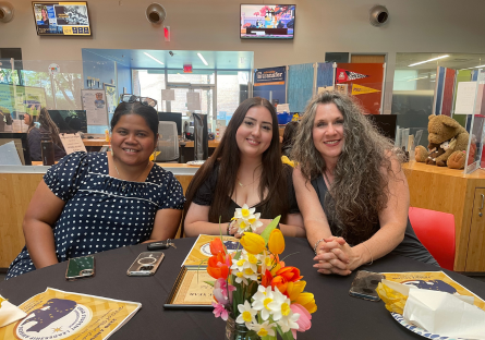 Phoenix College Education Director Kat Valdivia sits next to two members of the Future Teachers Club in PC's student union during the URSA Awards Ceremony