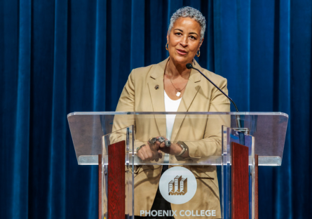 PC Athletic Director Kristine Kincaid stands at the PC podium on the Bulpitt Auditorium stage during the celebration ceremony