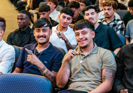 Phoenix College Men's soccer 2025 players sit in the Bulpitt Auditorium showing off their championship rings 