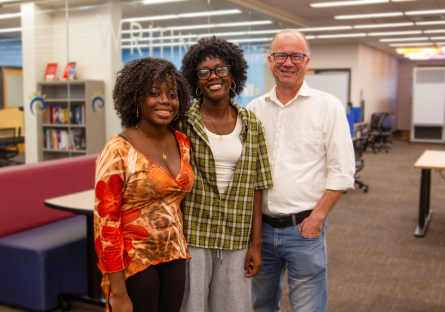 Shadé and Sy'nai Ajayi pose in the Learning Commons with Office Specialist and author Steven Dunham