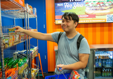 PC student making a selection from the shelves in Bumstead's Resource Room