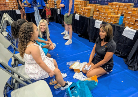 Volunteers helping children pick out shoes