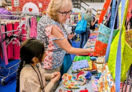 Adult volunteer helping a young child pick out bags