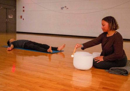 Phoenix College yoga instructor Ashley Burns plays crystal singing bowls with student Woong Yu in Shavasana