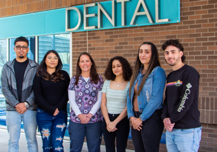PC Dental Hygiene scholarship recipients with their faculty member standing outside dental building