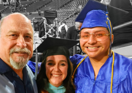 Jesse Lopez Martin posing in graduation regalia with two alumni after 2025's commencement ceremony