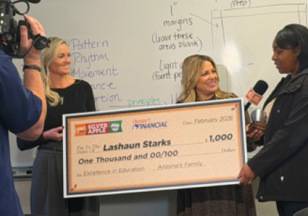 LaShaun Starks accepting $1,000 big check and silver apple award in her classroom
