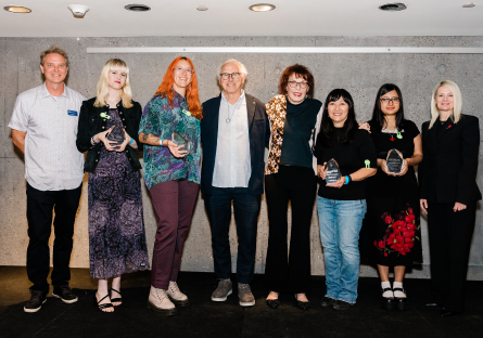 On a stage at the Phoenix Art Museum, Vanguard Award winners stand holding their awards with Phoenix College Art Program Director Jay Hardin, artist Eric Fischl, artist Marilyn Minter, and Phoenix College President Kimberly Britt