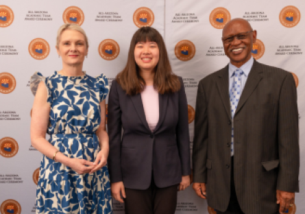 Olina Fong, dressed in a dark blue pant suit with pink top, stand between Dr. Kimberly Britt in a blue and white floral dress, and Wilbert Nelson, dressed in a dark gray suit at the All-AZ Academic Team ceremony