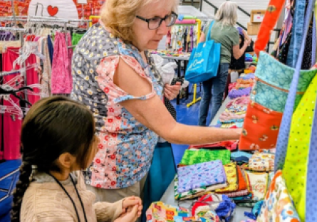 Adult volunteer helping a young child pick out bags
