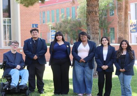 A group of Phoenix college students stand in front of a tree