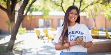 Female student siting outside at Phoenix College with cell phone in her hand