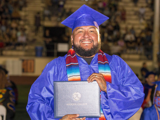 Phoenix College male student smiles broadly after receiving his diploma